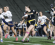 Female flag football players compete fiercely on the field, showcasing athleticism during an exciting game.