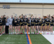 Group photo of the Tigers' female flag football team, celebrating together on the field before a game.