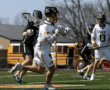 High school lacrosse players in action on the field, showcasing teamwork and athleticism during a game.