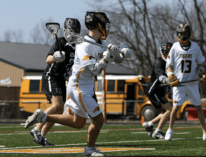 High school lacrosse players in action on the field, showcasing teamwork and athleticism during a game.