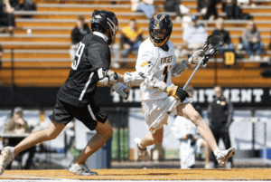 Lacrosse players compete on the field, showcasing athleticism and teamwork during a sunny match.