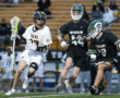 High school lacrosse players compete on the field, showcasing intense action and teamwork during the game.