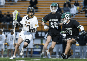 High school lacrosse players compete on the field, showcasing intense action and teamwork during the game.