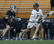 High school lacrosse players compete on the field, showcasing skill and athleticism in a dynamic match.