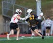 Lacrosse players compete on the field, showcasing athleticism and teamwork during a dynamic game moment.