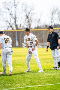 Baseball players in striped uniforms warming up on the field, showcasing teamwork and athleticism.