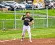 Baseball player in black Tigers uniform preparing to catch a fly ball on a sunny day at the diamond.