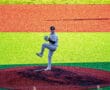 Young pitcher on the mound warming up, wearing grey uniform against vibrant green and red field background.