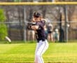 High school baseball player preparing to throw from second base on a sunny day at the field.