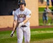 Baseball player in striped uniform prepares to bat on the field, showcasing focus and athleticism during the game.