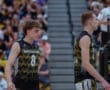 North Allegheny volleyball players on the court, focused during a competitive match with cheering fans in the background.