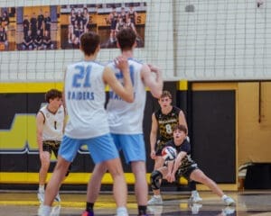 Boys' volleyball players in action during a match, focusing on teamwork and gameplay dynamics on the court.