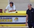 North Allegheny Tigers basketball scene with a coach observing and announcer at the table during a game.