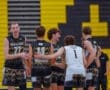 North Allegheny high school volleyball team celebrating a point, featuring players in jerseys against a vibrant backdrop.