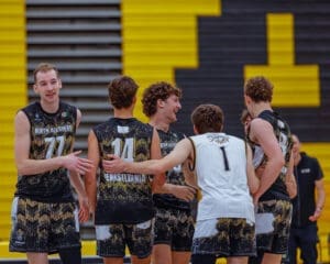 North Allegheny high school volleyball team celebrating a point, featuring players in jerseys against a vibrant backdrop.