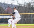 Baseball pitcher ready to throw on the mound during a game, wearing a striped jersey and black cap.