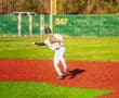 Baseball player fields a ball on vibrant turf, showcasing athleticism on the diamond during a sunny day.