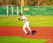 Youth baseball player in action on a vibrant field, preparing to field a ground ball during a game.