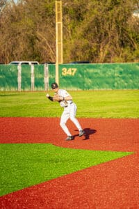 Youth baseball player in action on a vibrant field, preparing to field a ground ball during a game.