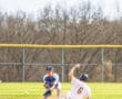Two young baseball players in action on the field, one sliding into second base while the other prepares to tag him.