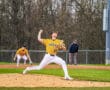 High school baseball pitcher in action, wearing a yellow Tigers uniform, on the mound during a game.