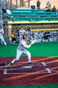 Baseball player in a batting stance with spectators in the background at a lively sports event.