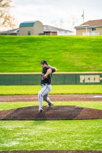 Baseball pitcher in action on the mound, focused and ready to throw during a game on a sunny day.