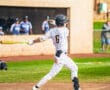 Baseball player swings bat at home plate during a game, showcasing athleticism and focus on the field.
