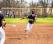 A baseball player from the Tigers team makes a dynamic throw during a game on a sunny day.