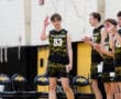 North Allegheny basketball player, number 83, waves to the crowd as teammates applaud during a game.