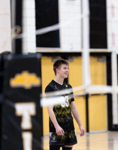 Smiling volleyball player in a North Allegheny jersey, enjoying a moment on the court during a game.