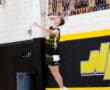 High school volleyball player serves during a match, showcasing athleticism and focus on the court.