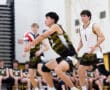 High school volleyball player prepares for a serve; teammates and spectators watch from the sidelines.