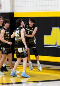 North Allegheny volleyball players celebrate a victory, showcasing teamwork and excitement on the court.