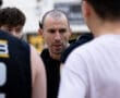 Coach instructing a basketball team during a huddle, emphasizing teamwork and strategy on the court.