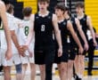 High school volleyball players shake hands after a match, showcasing sportsmanship in a competitive environment.