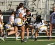 Action-packed moment in girls' flag football game with players competing for possession on the field.