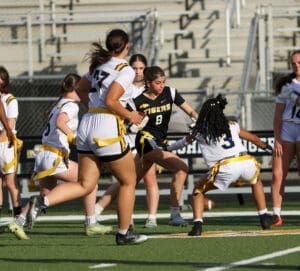 Action-packed moment in girls' flag football game with players competing for possession on the field.