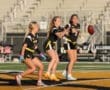 Girls' flag football team training, showcasing teamwork and agility on the field during practice.
