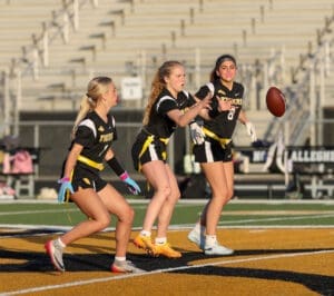 Girls' flag football team training, showcasing teamwork and agility on the field during practice.