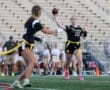 Female flag football player throws a ball during a game, showcasing athletic skill and teamwork on the field.