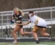 High school girls' flag football action, one player running with the ball while the other reaches to tag her.