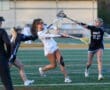 High school girls' lacrosse match with players in action on the field, showcasing teamwork and athleticism.