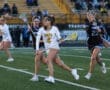 High school girls' lacrosse players compete on the field, showcasing athleticism and teamwork in an exciting match.