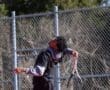 A young tennis player serves the ball on a sunny court, showcasing focus and athleticism during practice.