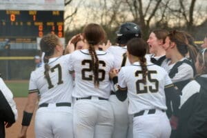 Cheering softball team celebrates a victory on the field, showcasing team camaraderie and excitement.