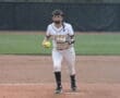 Softball player in a Tigers jersey prepares to pitch on a field, showcasing athletic action and team spirit.