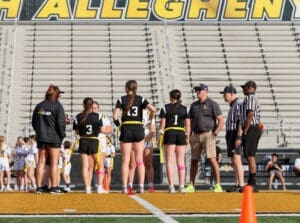 Cheerful flag football players and coaches meet referees at the field before a game, showcasing teamwork and sportsmanship.