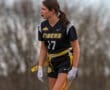 Female flag football player in a Tigers uniform, focused on the game, with a determined expression and yellow belt.