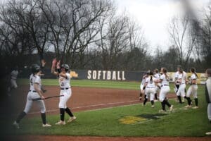 Softball players celebrate a victory at the field, showcasing teamwork and enthusiasm during a game.